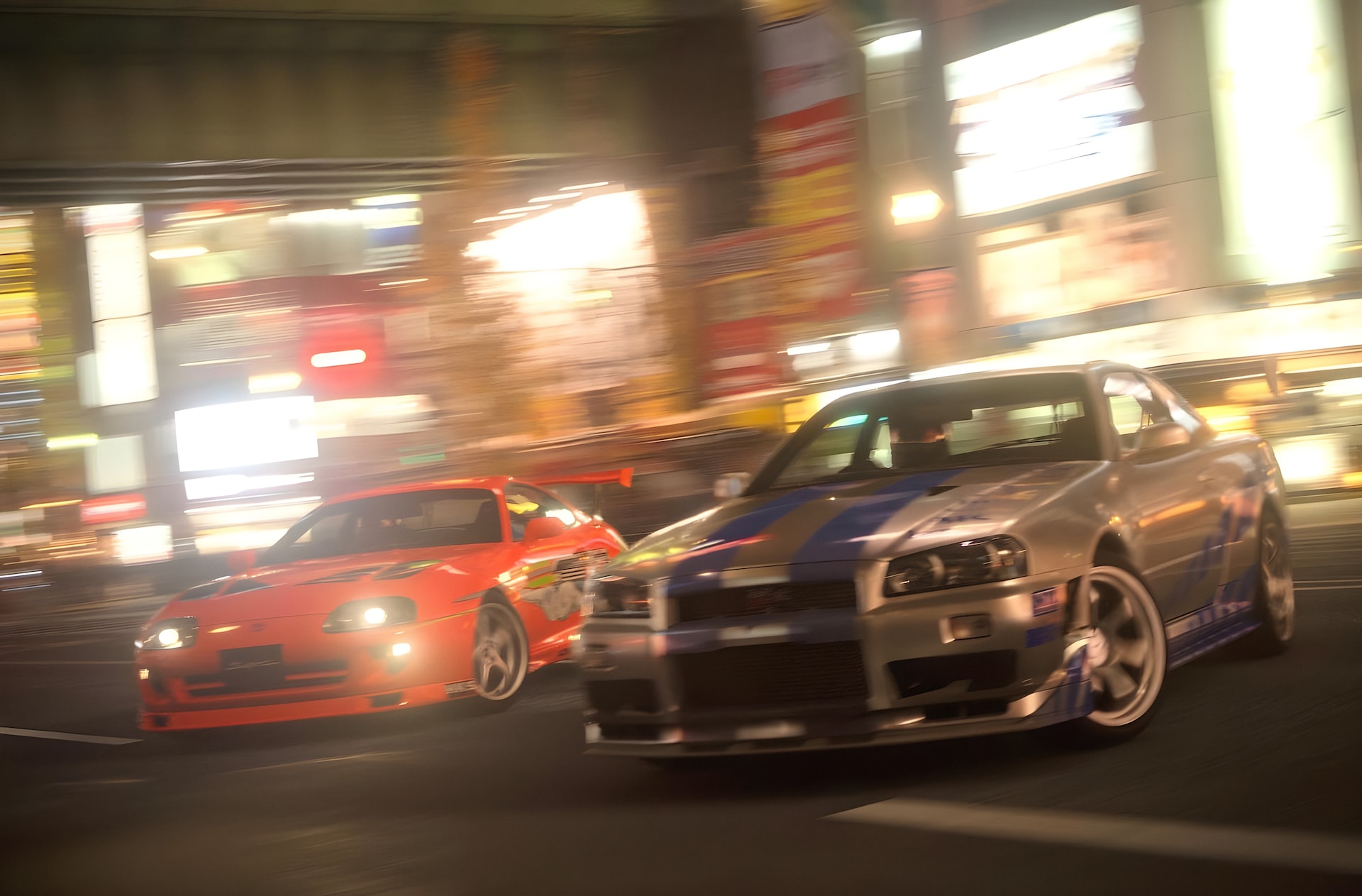 two cars driving down a city street at night